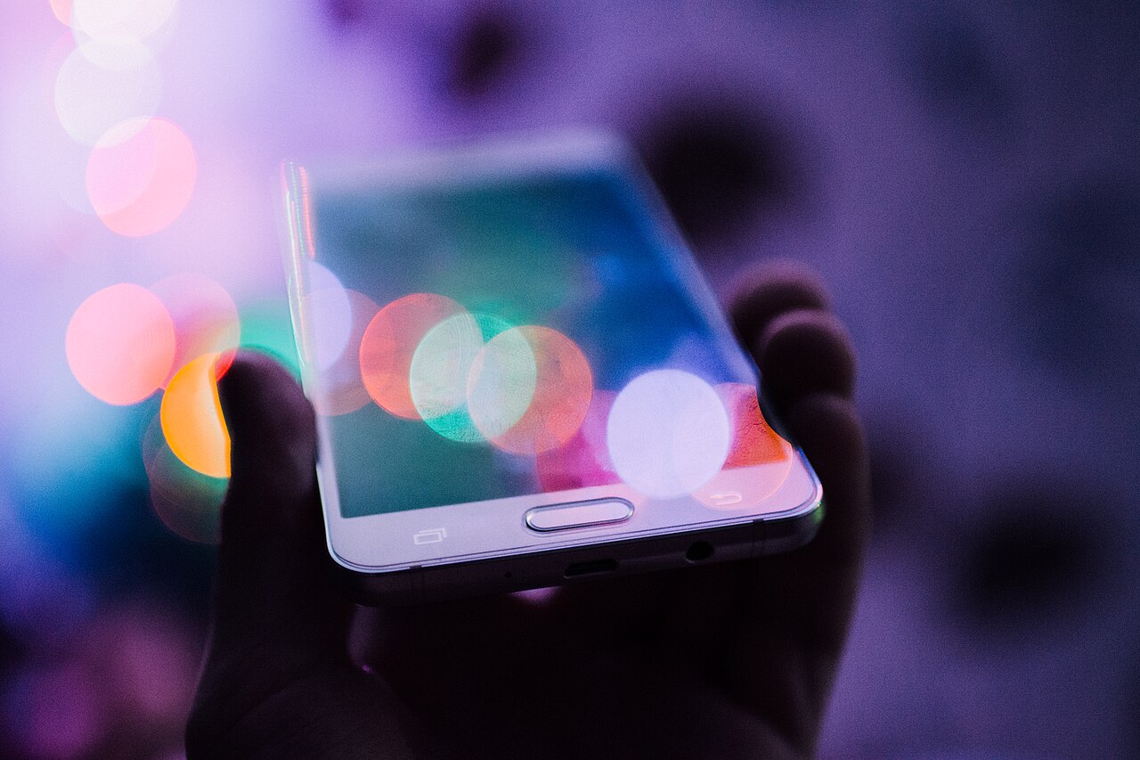 Hand holding a smartphone while reading a message